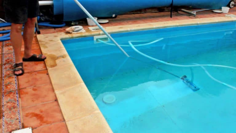 vacuuming above ground pool with sand filter