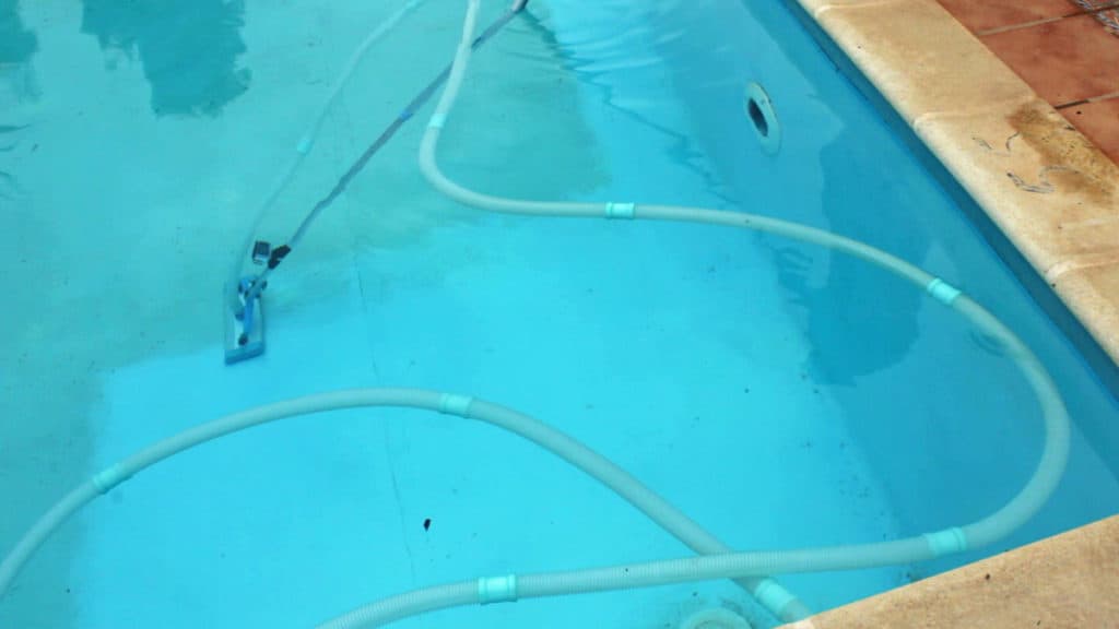 Clean an inground pool with a sand filter using a vacuum