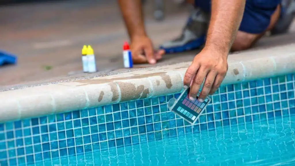 How Often Should You Test Your Pool Water - man testing pool water